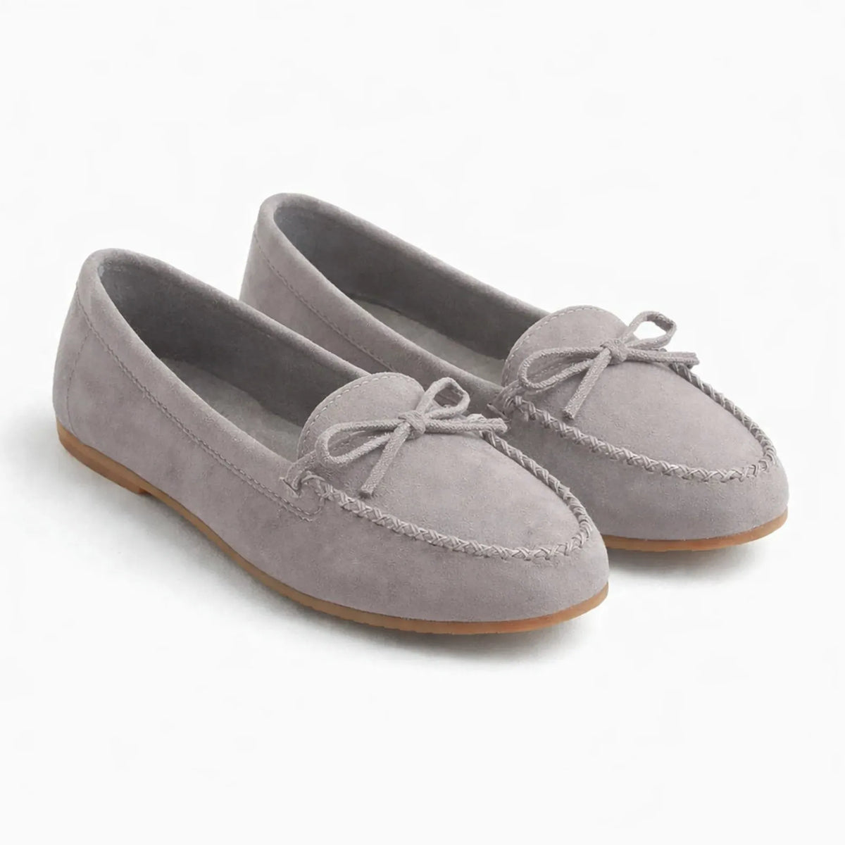 paire de mocassins gris clair vue de trois quarts sur fond neutre