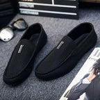 paire de mocassins noirs posée sur un tapis avec accessoires lifestyle autour