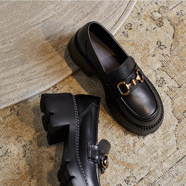 Vue rapprochée de deux mocassins noirs posés sur un tapis clair