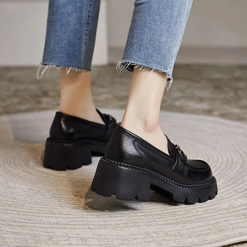 Mocassins noirs à semelles épaisses portés, angle arrière sur tapis rond