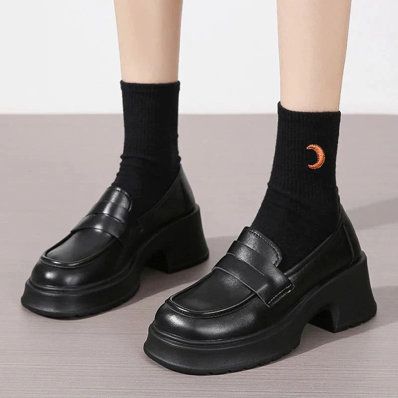 Vue de face de la paire noire portée avec chaussettes noires à motif