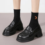 Vue de face de la paire noire portée avec chaussettes noires à motif
