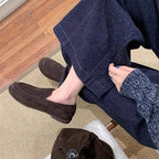 paire marron portée avec un pantalon ample bleu sur un sol en moquette beige