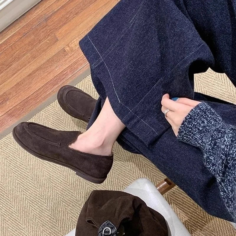 paire marron portée avec un pantalon ample bleu sur un sol en moquette beige