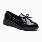 mocassin vernis à noeud noir posé sur fond uni