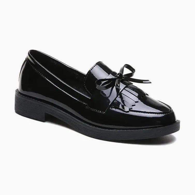 mocassin vernis à noeud noir posé sur fond uni