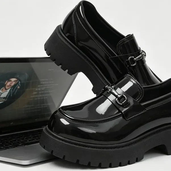 paire de mocassins noirs vernis posée sur un ordinateur portable, côté brillant visible