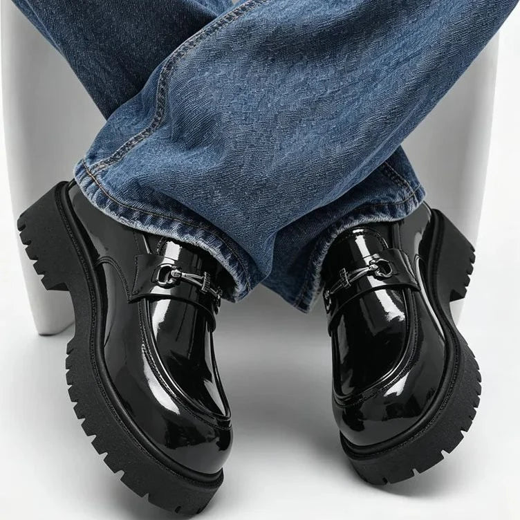 mocassins noirs vernis portés, pieds croisés sous une chaise, vue de face