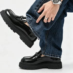 mocassins noirs vernis portés avec un jean large, vue de profil
