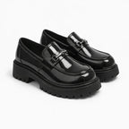 mocassin vernis noir homme à plateforme présenté de trois quarts sur fond uni