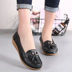 Vue de face de mocassins noirs portés, debout, jambes croisées