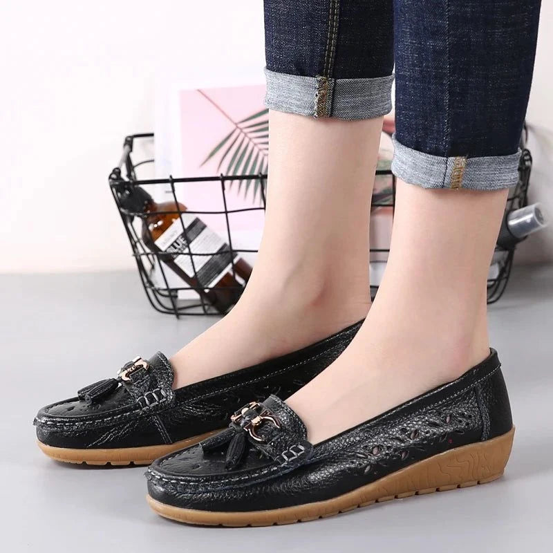 Une paire de mocassins noirs portée avec un pantalon en jean retroussé