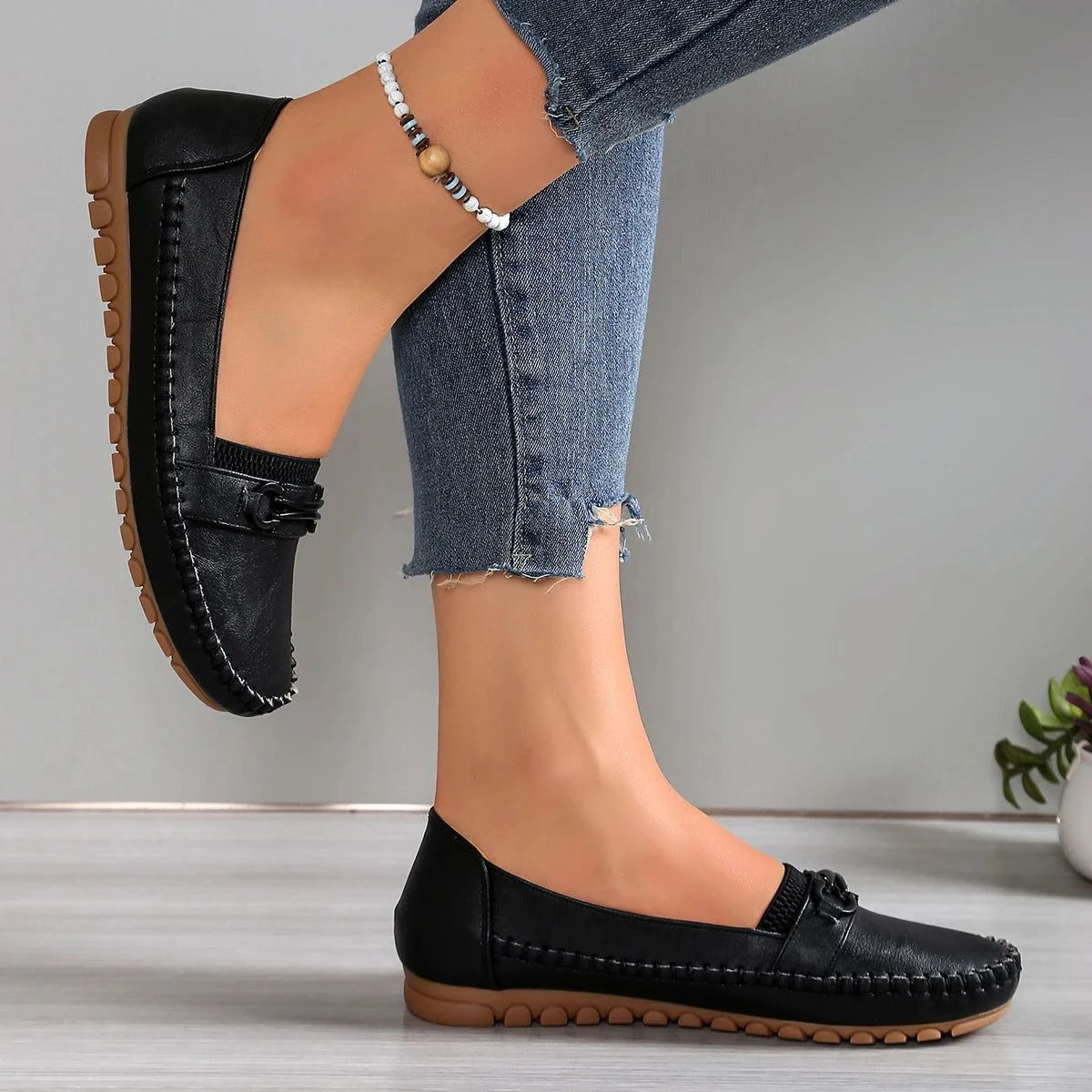 profil latéral des mocassins noirs portés avec un jean ajusté