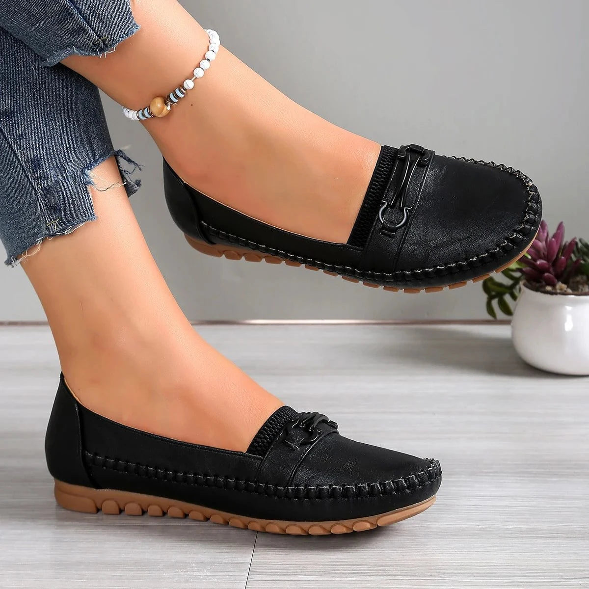 paire noire portée avec un pantalon en jean et un bracelet de cheville