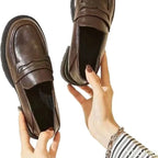 Autre vue des chaussures marron tenues dans les mains au niveau du devant