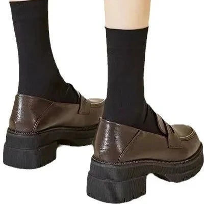 Loafers marron vus de dos, portés avec des chaussettes noires montantes