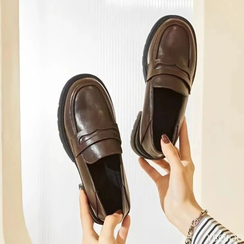 Chaussures portées avec des jambes croisées, mettant en valeur la couleur marron