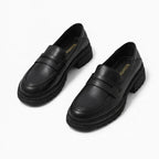 Penny loafers femme noires à semelle épaisse présentées sur fond blanc
