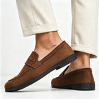 vue arrière de mocassins marron portés, pied relevé montrant la semelle